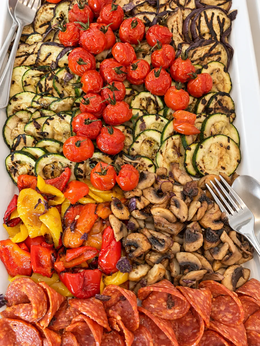 Buffet mit gegrilltem Gemüse, Tomaten, Pilzen und Salami